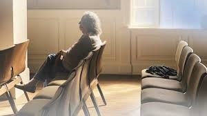 A woman sits quietly in meditation at the Quaker Center